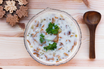 Chanterelle Cream Soup  with fresh herbs on a wooden background