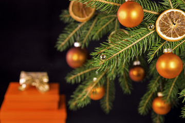 orangene Weihnachtskugeln an Tannenzweig