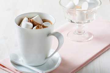 Cup of hot chocolate  with marshmallow on a white table