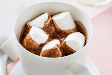 Cup of hot chocolate  with marshmallow on a white table
