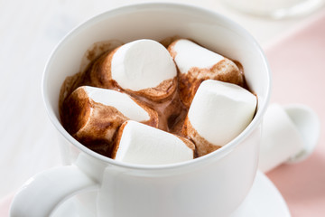 Cup of hot chocolate  with marshmallow on a white table