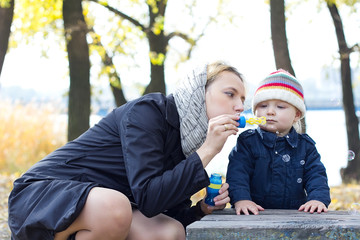 Mother with little son blowing bubbles