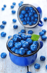 Delicious blueberries in cups on table