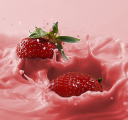 Delicious fresh strawberry falling into splashing milk © Africa Studio