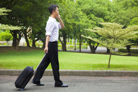 businessman walking and using a phone on the road