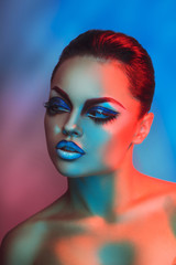 Fashion model in red and blue lights with healthy skin and makeu