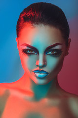 Glamour adult brunette with make up in red and blue lights