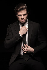 business man sitting and fixing his tie