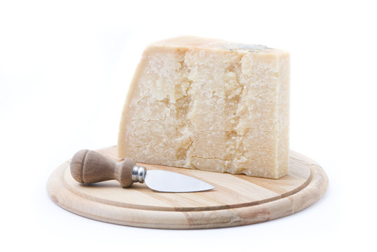 formaggio grana su tagliere rotondo con coltello