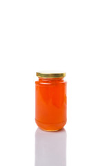 Orange fruit jam in a bottle over white background
