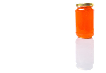 Orange fruit jam in a bottle over white background