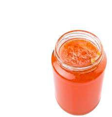 Orange fruit jam in a bottle over white background