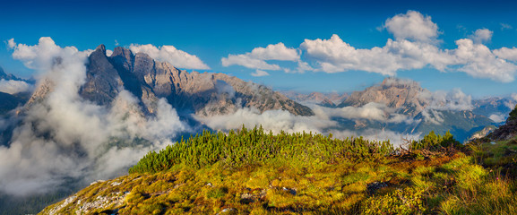 Gruppo Del Cristallo mountain range at foggy summer morning. Dol