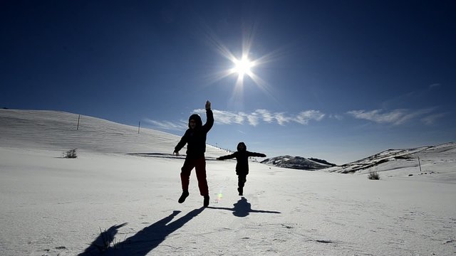 Kids silhouettes running on the snow