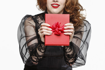 Glamorous woman holding red present box with big bow