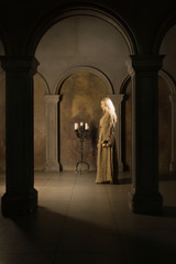 Nun praying in a medieval church