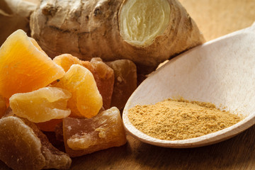 Candied fresh and ground ginger on rustic table
