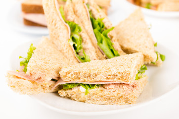 ham and lettuce sandwich on a white plate