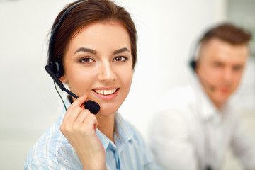 Businesswoman with headset smiling at camera in call center