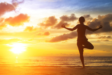 Fototapeta na wymiar Yoga girl silhouette on the beautiful sea beach.