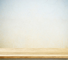 Empty wooden table over cement wall.