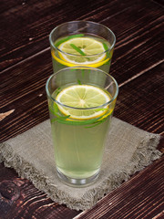 Lemonade with fresh lemon on wooden background