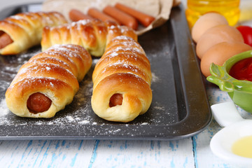 Baked sausage rolls in pan on table close-up