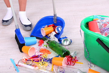 Woman cleaning grey wooden floor from mess