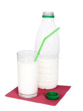 Bottle and glass of milk with green drinking straw on red napkin