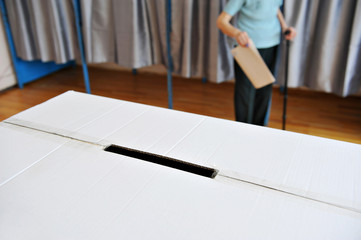 Old person in cane voting