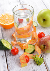Glass of water with vegetables and measuring tape