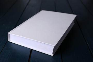 White book on wooden table, close-up
