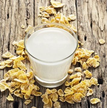 Milk and conflake on table wooden background