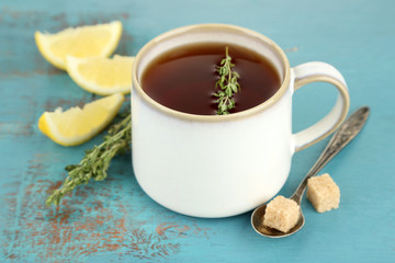 Cup of tasty herbal tea with thyme and lemon