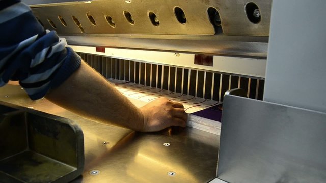 Industrial cutting knife cutting the printed material