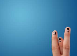 Happy smiley face fingers looking at empty blue background copy