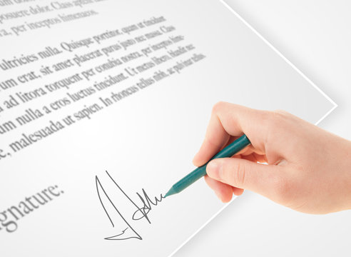 Hand writing personal signature on a paper form