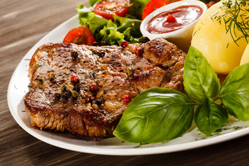 Grilled steak, boiled potatoes and vegetable salad