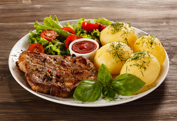 Grilled steak, boiled potatoes and vegetable salad