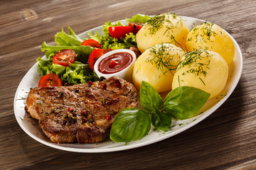 Grilled steak, boiled potatoes and vegetable salad
