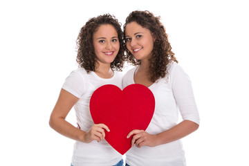 Fototapeta na wymiar Rotes Herz Konzept: zwei lachende Mädchen; reale Zwillinge