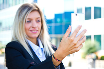 Beautiful business woman takes a selfie with her cell phone