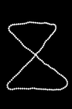 Thread of faux pearls as hourglass