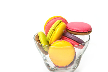 Colorful macaroons in cocktail glass on white background