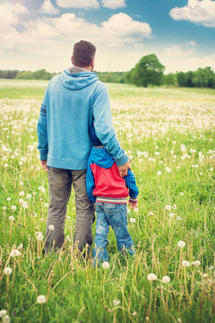 Father and son on dandelion field