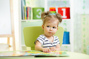 cute happy little girl reading a book