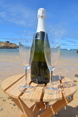 Two Glasses Of Champagne And Bottle On The Beach