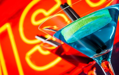 detail of cocktail with neon disco word background