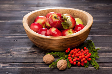 Red apples in a wooden bowl. Autumn composition.
