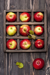 Red apples in  wooden box. Collage.